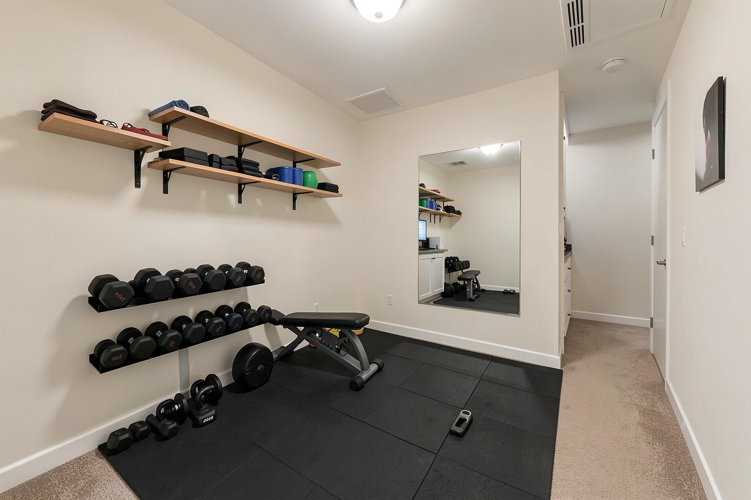 Organized small home gym with wall storage and open floor space