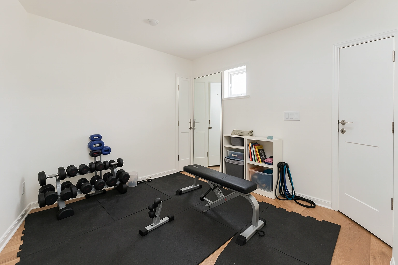 Compact beginner home gym with adjustable dumbbells bench and flooring