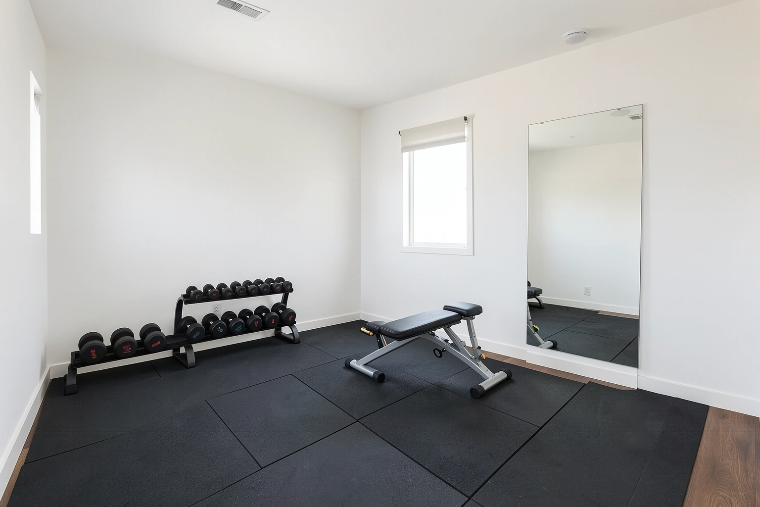 Spare room converted into a small home gym with open floor space and basic equipment